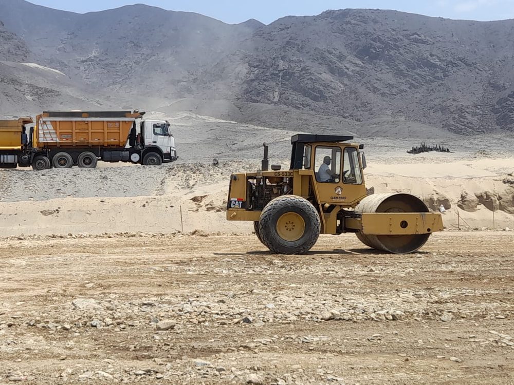 Rodillo compactador CAT y volquete de la flota en obra de movimiento de tierra