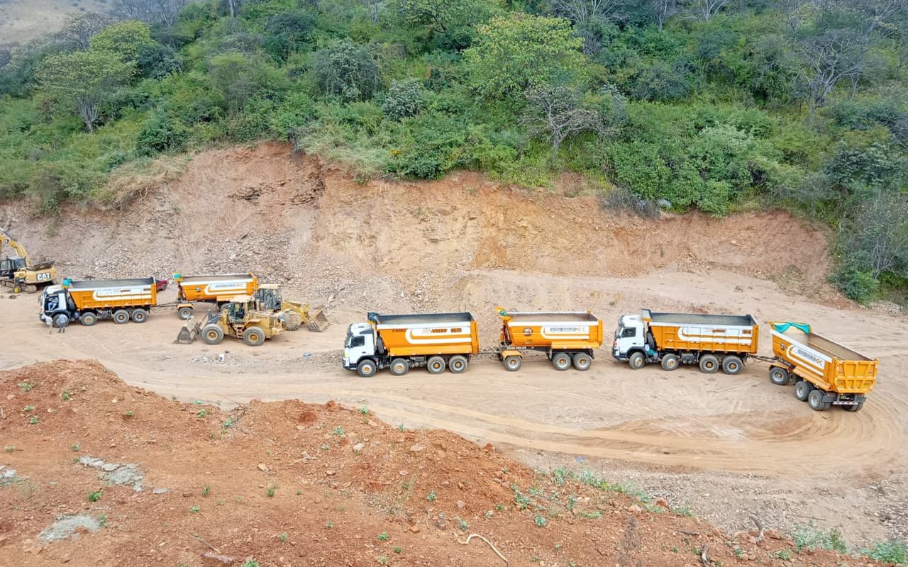 Flota de volquetes Anderson David y cargador CAT en operación de carga pesada
